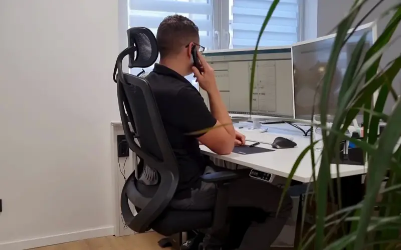 Planer bei SiwuPlan am Telefon vor zwei Bildschirmen mit Plänen
